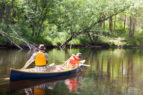 Father & son paddling canoe river